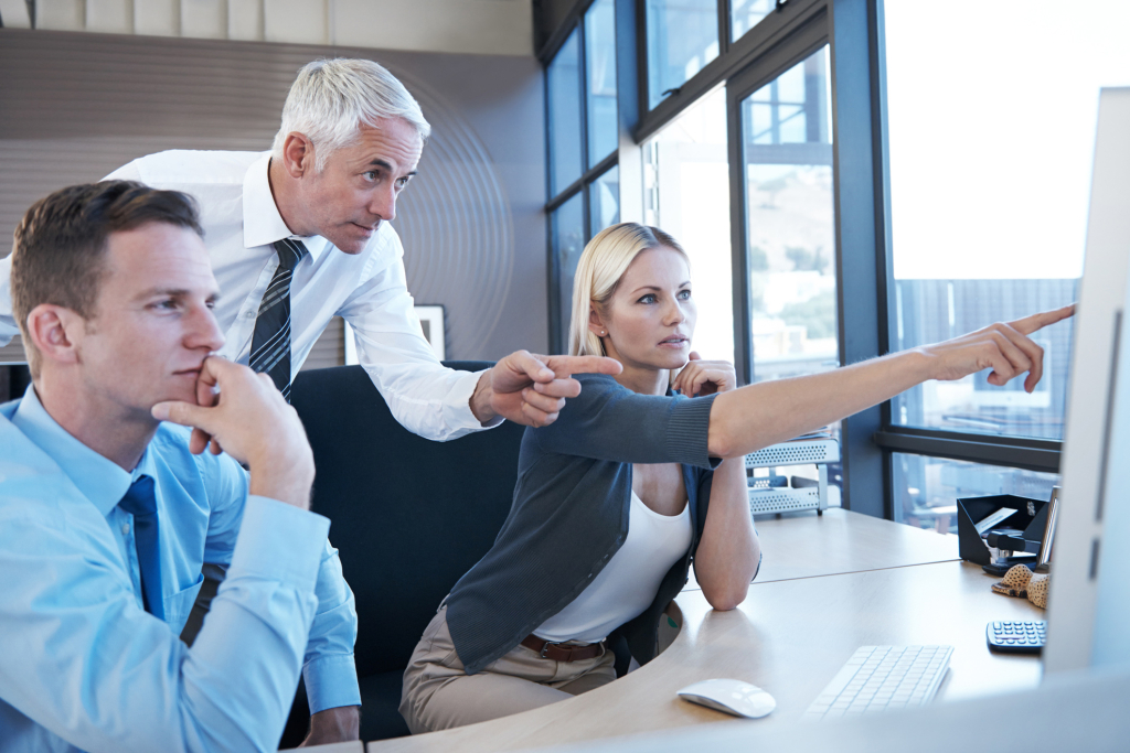 a group of people discussing and pointing to a chart contemplating financial decision making